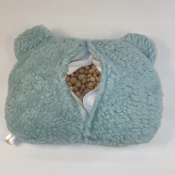 Wärmekissen Bär in Farbe mint. Zu sehen ist die Rückseite. Der Klettverschluss vom Überzug und vom Innenkissen ist geöffnet und die Kirschkerne sind zu sehen. Kirschkernkissen speichern die Wärme bist zu 25 Minuten. Das Kirschkernkissen Bär kann mit Überzug in der Mikrowelle aufgewärmt werden.