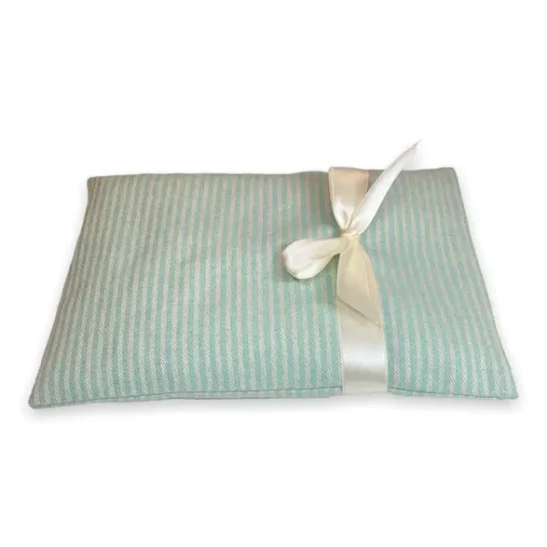 Aufwärmbares Kirschkernkissen mit Satinbandschleife, hergestellt aus Baumwollstoff. Der Überzug von diesem Wärmekissen ist waschbar und in zarter mint Farbe hergestellt.